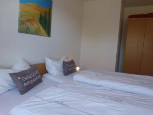two beds in a room with a painting on the wall at Ferienwohnung Sauerlandblick in Korbach