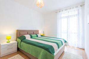 1 dormitorio con 1 cama con manta verde y blanca en Villa Nick, en Cavtat