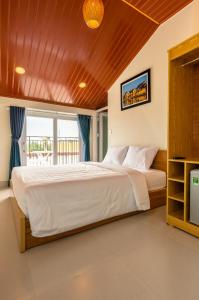 ein Schlafzimmer mit einem großen Bett und einem Fenster in der Unterkunft D Central Hoi An Homestay in Hoi An