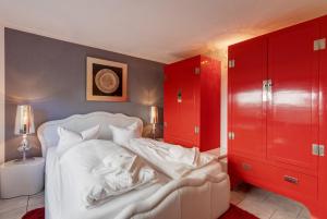 アールベックにあるFerienwohnung Kieferngrundのベッドルーム1室(白いベッド1台、赤いキャビネット付)