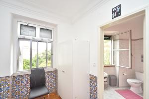 a bathroom with a toilet and a window at Brother's Rooms in Lisbon