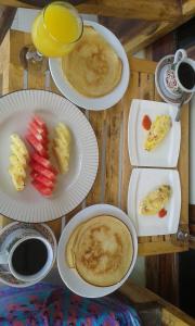 a table topped with plates of breakfast foods and drinks at Village Corner Homestay in Kuta Lombok