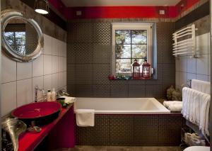 a bathroom with a tub and a red sink at Fisher House in Sopot