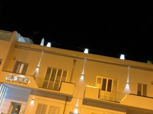 a building with lights on the side of it at night at Onda B&B in Porto Cesareo