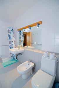 a white bathroom with a toilet and a sink at Buganvilija C6 in Veli Lošinj