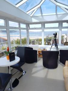 a living room with a table and chairs and windows at The Penellen guest accommodation room only in Hayle