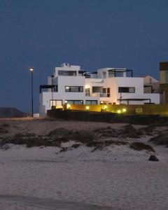 コティージョにあるApartamento en El Cotillo primera lineaの海岸灯台付きの大きな白い家