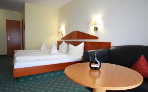 a hotel room with a bed and a wine bottle on a table at Weinhotel Rose in Volkach