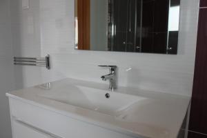 lavabo blanco en el baño con espejo en Maria Violeta Tourism Apartment, en Cadaval