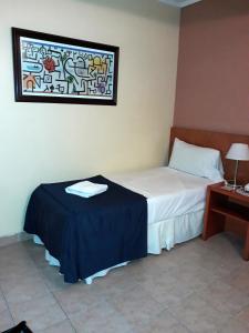 a bedroom with a bed with a table and a window at Hotel UTHGRA de las Luces in Buenos Aires