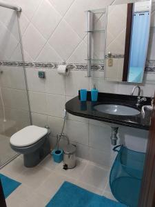 a bathroom with a sink and a toilet and a mirror at Casa em Ponta Negra in Natal