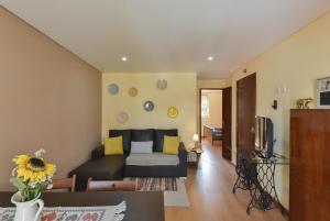 ein Wohnzimmer mit einem Sofa und einem TV in der Unterkunft Clerigos Old Town Apartment in Porto