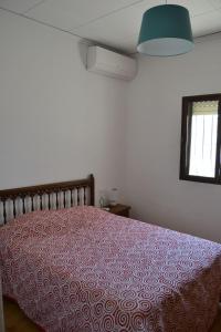 - une chambre avec un lit et une couverture rouge dans l'établissement Carolina LOCDENIA, à Dénia
