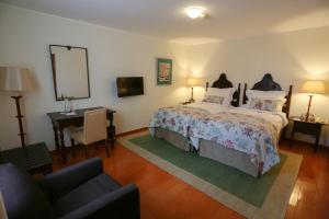 1 dormitorio con cama, escritorio y espejo en Pousada de Valença, en Valença