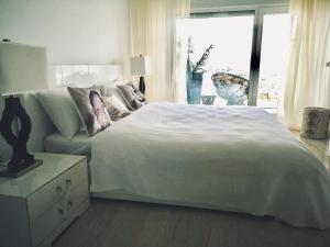 a bedroom with a white bed and a window at White Tower Mamaia - Private Apartment in Mamaia +24 photos
