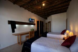 a hotel room with two beds and a desk at Hôtel Kadiandoumagne in Ziguinchor