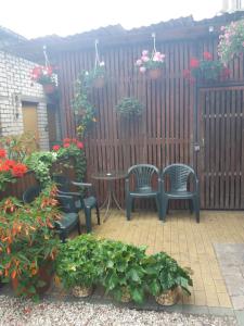 a patio with chairs and a table and flowers at Ventspils Apartments in Ventspils