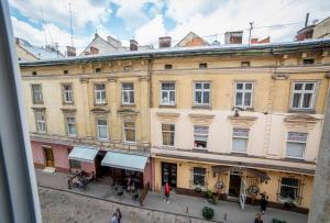 un edificio en una ciudad con gente caminando por una calle en Апартаменти в центрі Львова - 1 хв до Площі Ринок, en Leópolis