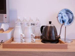 a tray with a tea kettle and bottles of water at Miss inn in Magong