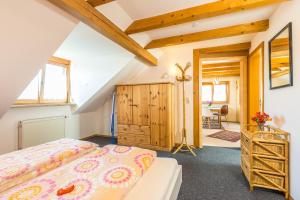 リンダウにあるFerienwohnungen Haus Christineのベッドルーム1室(ベッド1台付)、木製キャビネットが備わります。