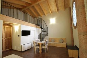 ein Esszimmer mit einem Tisch und einer Wendeltreppe in der Unterkunft ALL'ALBARO AGRITURISMO in Salizzole