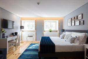 - une chambre avec un lit, un bureau et une table dans l'établissement Virtudes City Lofts, à Porto
