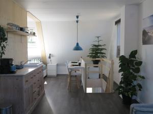a kitchen with a table and a small table with chairs at B&B Zonnedael in Oosterend
