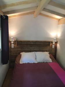 a bedroom with a bed with a wooden headboard at Camping Mon Repos in Montmaur +40 photos