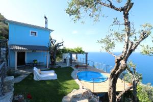 a house on the edge of the water with a swimming pool at Fakistra's Blue House in Tsagarada