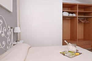 um quarto com uma cama branca e um closet em Sweet Rome Colosseo em Roma