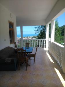 a living room with a table and chairs on a balcony at Guest house maka in Gonio