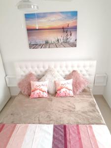 サン・ペドロ・デル・ピナタルにあるLo Pagán luxus modern beach bungalowのベッドルーム1室(ピンクの枕と絵画付)