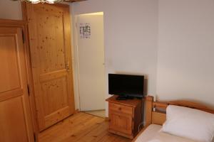 a bedroom with a bed and a television on a dresser at Hotel Lowen in Walenstadt