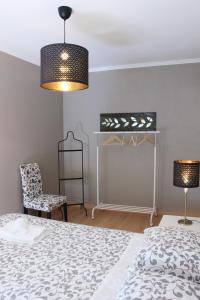 a bedroom with a bed and a chair and a lamp at Casa da Linha in Cascais