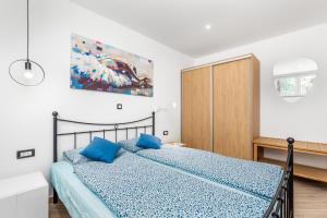 a bedroom with a blue bed and a wooden cabinet at Apartments Linda in Mošćenička Draga
