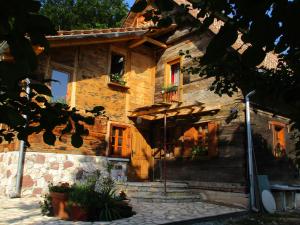a wooden house with an umbrella in front of it at Rooms S&I Korana in Slunj