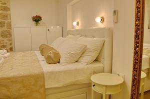 a bedroom with a white bed and a mirror at Villa Madonna della Strada A3 in Dubrovnik