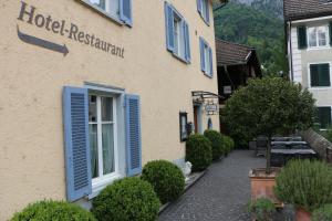 un hotel con persianas azules en un edificio en Hotel Lowen, en Walenstadt