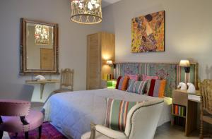 a bedroom with a bed and two chairs and a mirror at Hôtel St Pierre in Saumur