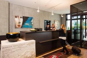 Eine Frau, die an einem Tresen in einem Museum steht. in der Unterkunft Hotel am Campus in Ingolstadt