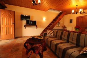 a living room with a couch and a staircase at Fakistra's Blue House in Tsagarada