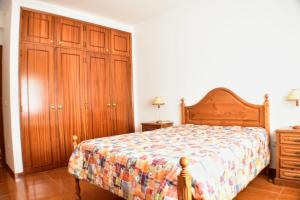 ゴーイスにあるCasa das Figueirinhasのベッドルーム1室(ベッド1台付)、木製キャビネットが備わります。