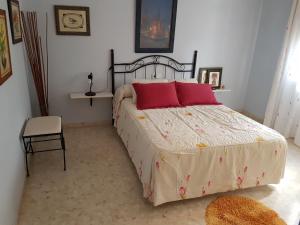 - une chambre avec un grand lit et 2 oreillers rouges dans l'établissement Casa Chalet Las Camelias, à Los Barrios