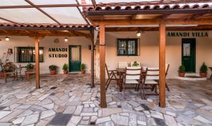 un patio al aire libre con mesa y sillas en Amandi Villa, en Karteros