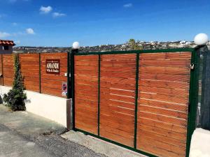 una valla de madera con una puerta con un cartel en Amandi Villa, en Karteros