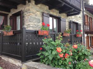a house with red flowers inpots on a fence at Dimora tra le Alpi - cir n 0004 in Introd