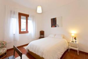 ポルトにあるCamarao Apartmentのベッドルーム1室(ベッド1台、椅子、窓付)