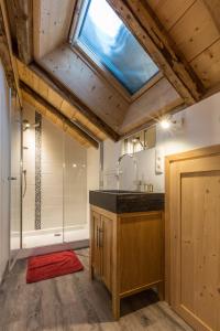 uma casa de banho com um lavatório e um chuveiro com uma clarabóia em Chalet Atelier Chalet Chamonix em Chamonix-Mont-Blanc