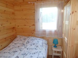 a bedroom in a log cabin with a bed and a window at Anielsko domki nad morzem in Mielenko