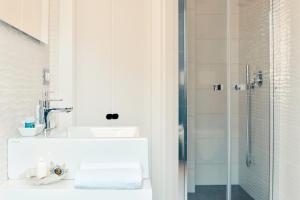 uma casa de banho com um lavatório e um chuveiro em Coral Bay Charming House em Alghero